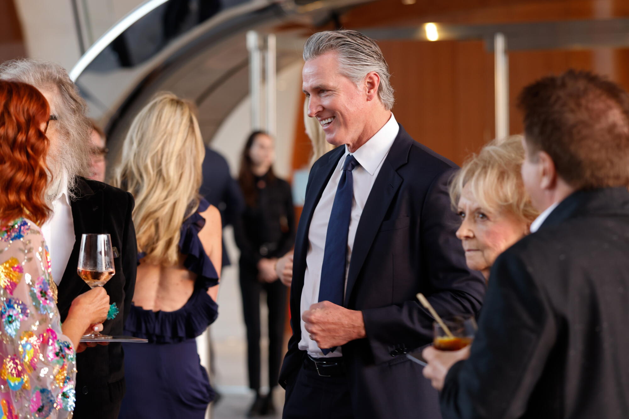 Gov. Gavin Newsom talks to guests at a party.