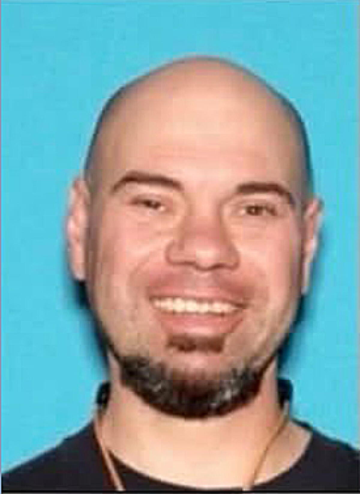 A mugshot of a smiling man.