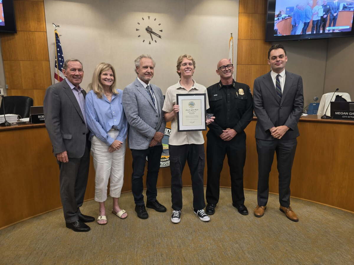 Bradley Beshear, a former Laguna Beach lifeguard, holds up a certificate for an act of bravery, recognizing an ocean rescue.