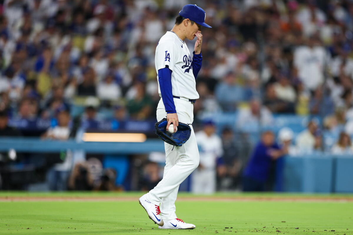 Yoshinobu Yamamoto reacts after a throwing error to third base in the fifth inning.