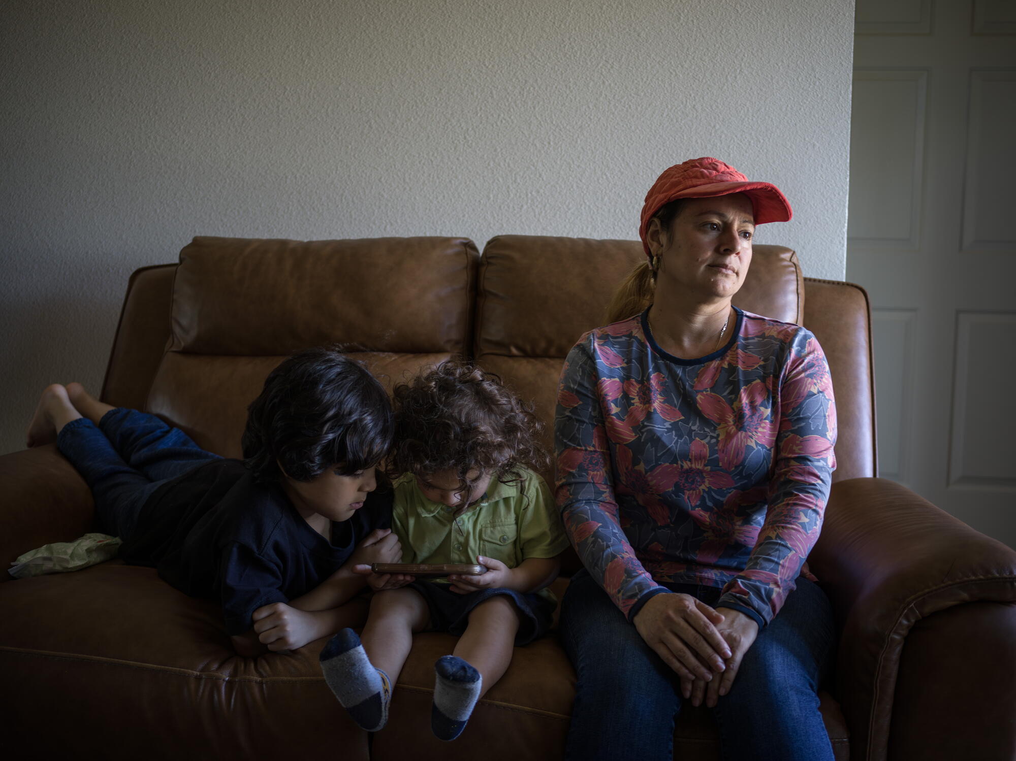 two children and their mother sit on a sofa