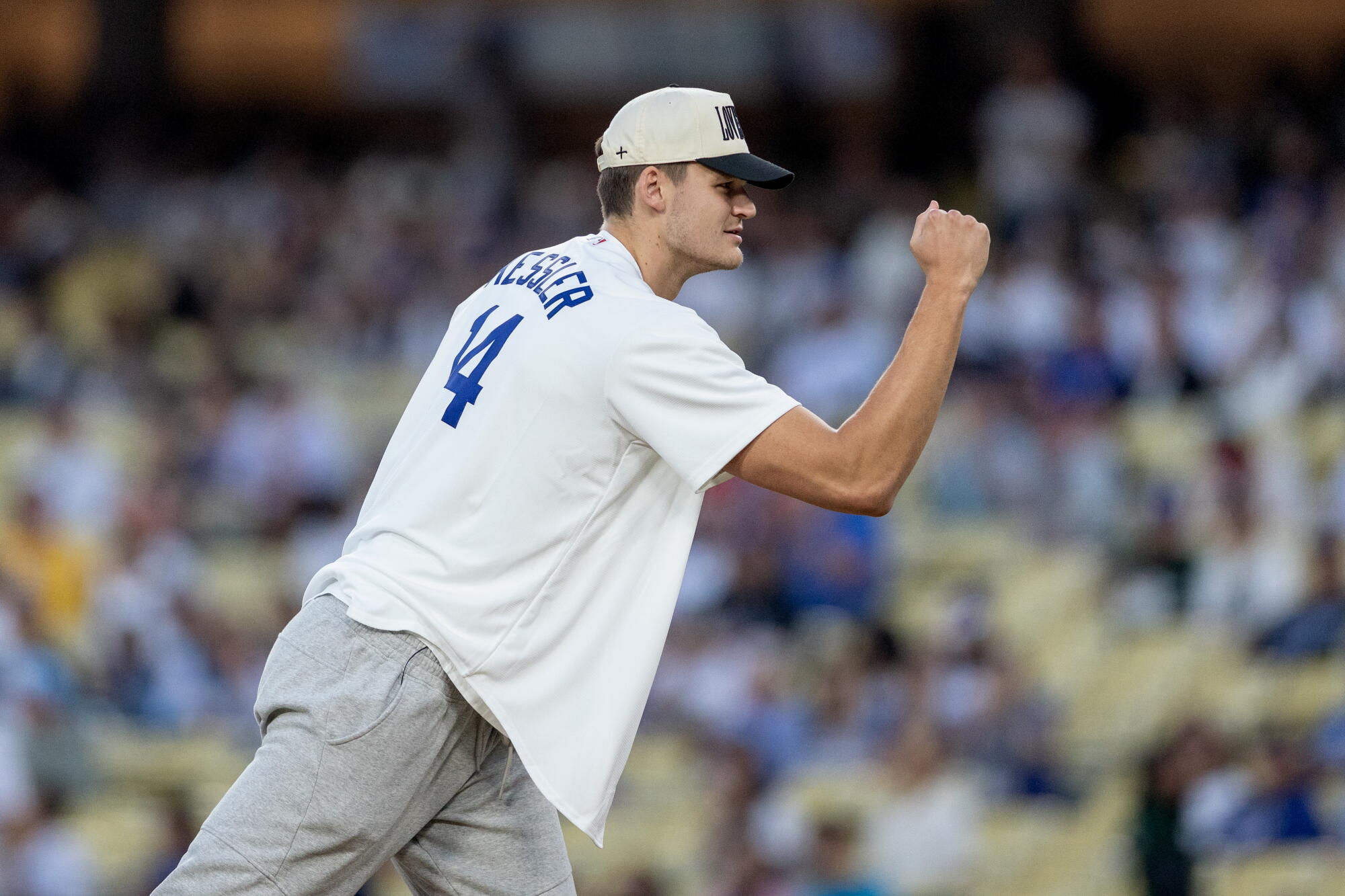 New Lakers center Walker Kessler pumps his right fist as he reacts after throwing out the first pitch before a Dodgers game.
