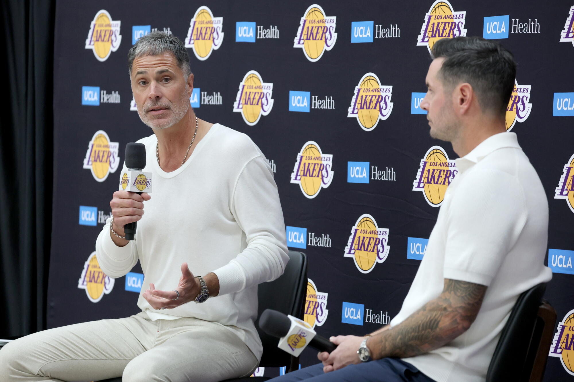 Lakers general manager/president of basketball operations Rob Pelinka, left, speaks to reporters as coach JJ Redick listens.