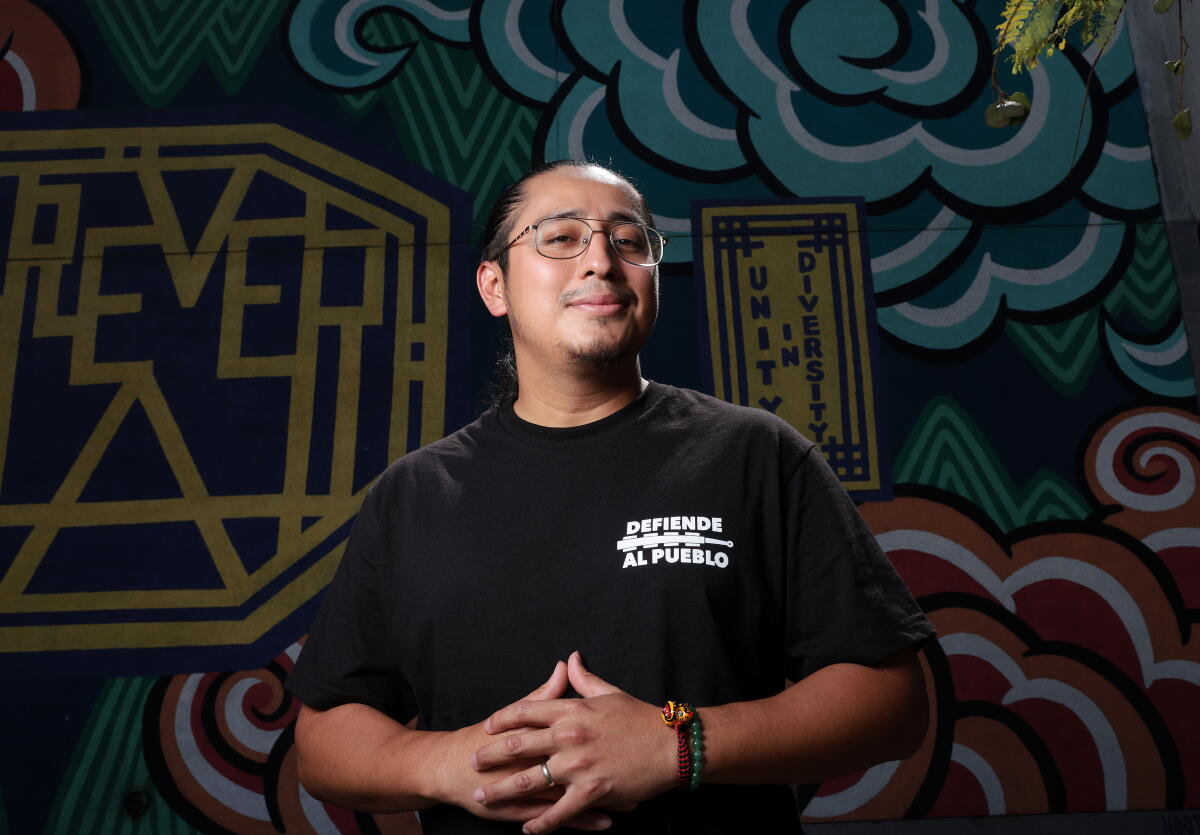a man poses infront of a mural