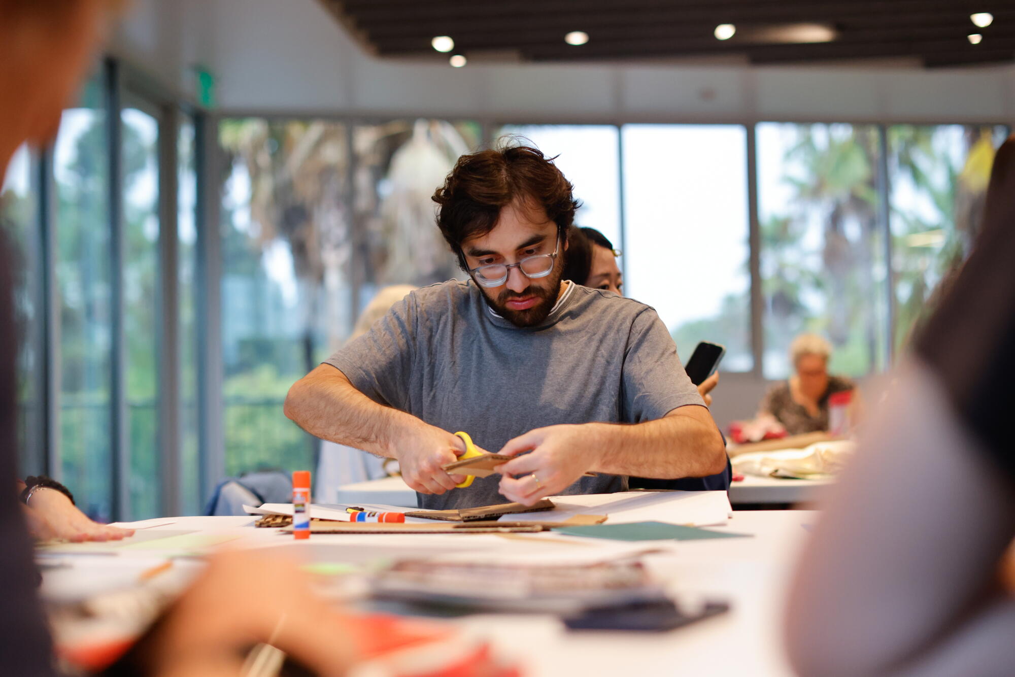 A man works on an art project at a table.