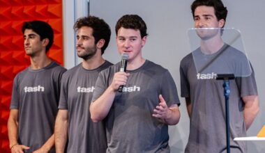 four students wearing tash t-shirts at an event