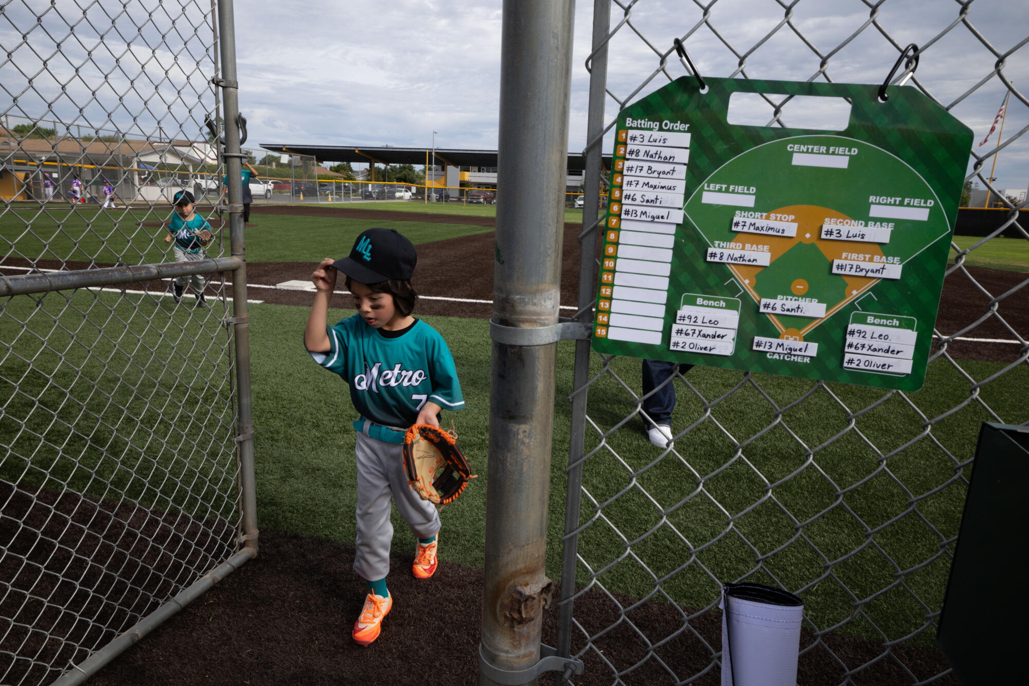 A Little League player walks off the field.