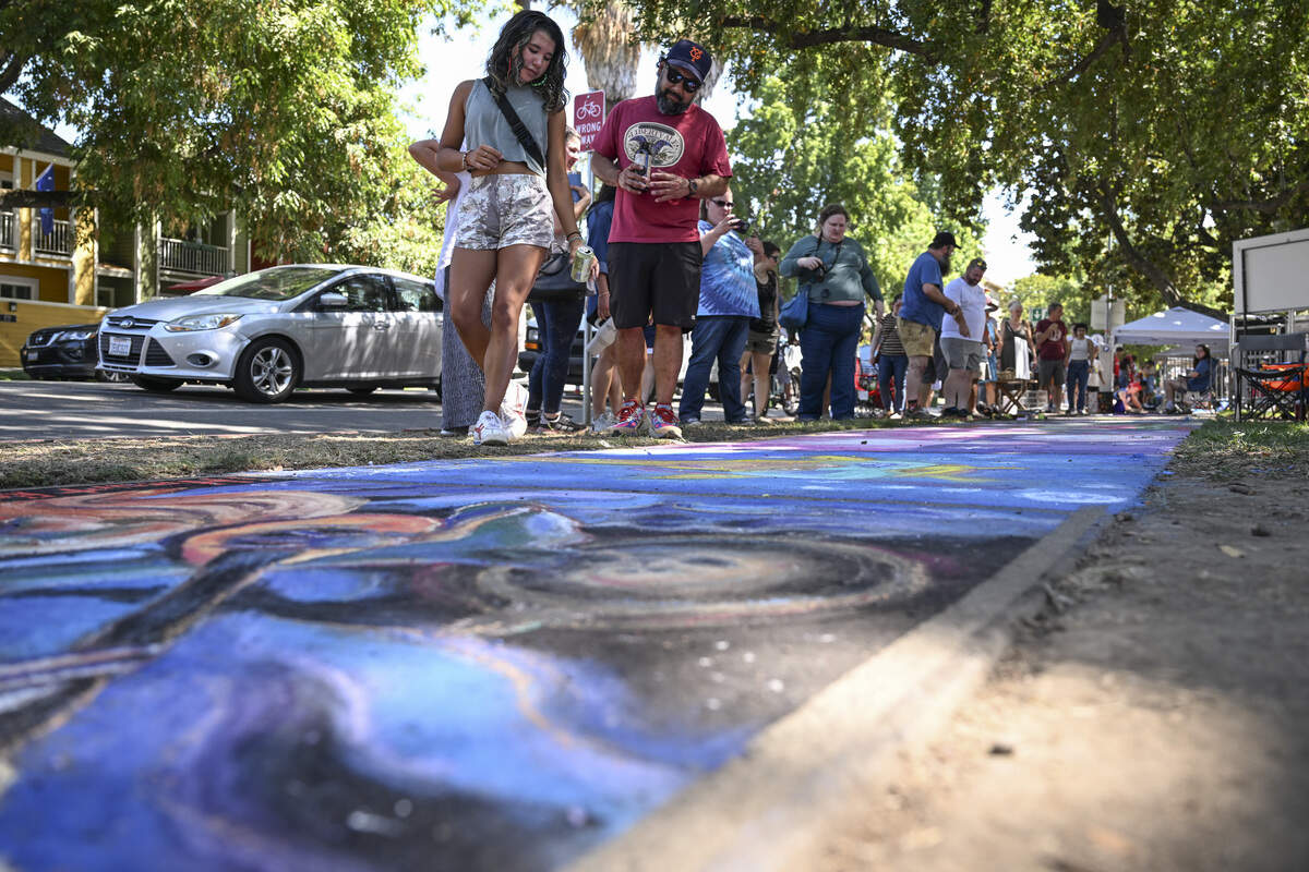 Festival attendees look at completed chalk drawings during Chalk It Up art festival at Fremont Park in Sacramento on Sunday, Aug. 31, 2025.