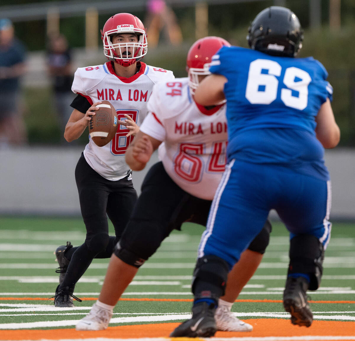 Mira Loma Matadors quarterback Deangelo Keys (6) drops back to pass as Valley Vikings defensive lineman Shane Williams (69) applies pressure on Thursday at Cosumnes River College.