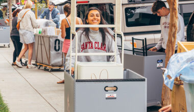 Student smiling pushing a mve-in cart on Welcome Weekend
