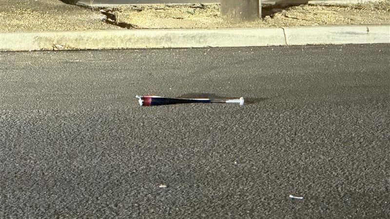 A baseball bat is seen lying in the roadway near Sierra Vista and Belmont avenues, where Fresno police investigated a stabbing. Police have not said whether the bat was involved in the altercation. (PHOTO: Courtesy FOX26 Photojournalist Chase Gauthier.)