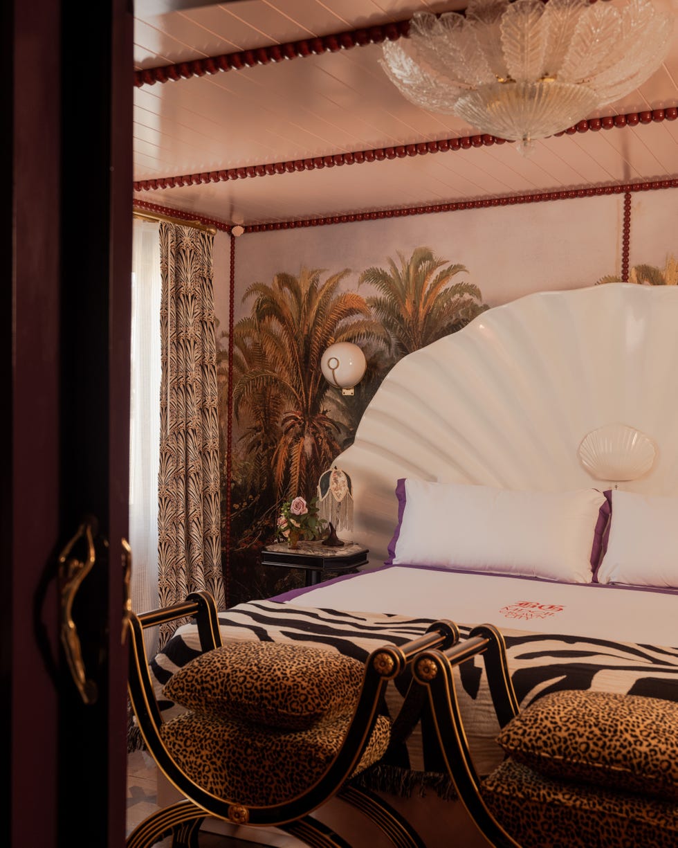 Stylish bedroom with tropical wallpaper, a shell-shaped headboard, and animal print accents.