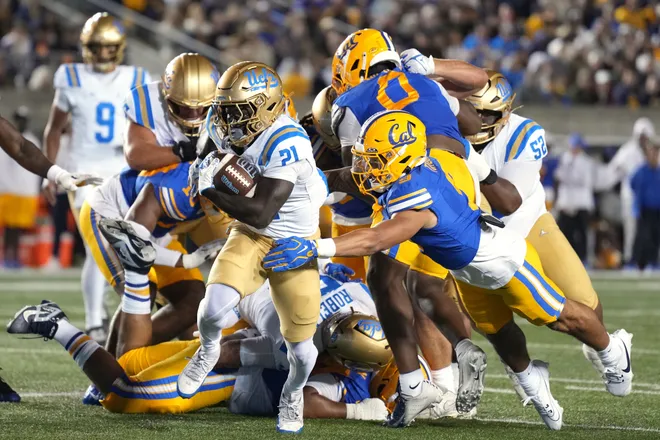 Sep 5, 2026; Berkeley, California, USA; UCLA Bruins running back Jaivian Thomas (21) breaks free of a tackle attempt by California Golden Bears linebacker AJ Tuitele (front right) during the second quarter at California Memorial Stadium. Mandatory Credit: Darren Yamashita-Imagn Images