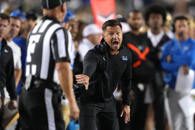 Sep 5, 2026; Berkeley, California, USA; UCLA Bruins head coach Bob Chesney (center) yells at field judge Timothy Maguire (left) during the first quarter against the California Golden Bears at California Memorial Stadium. Mandatory Credit: Darren Yamashita-Imagn Images
