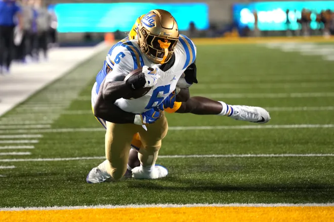 Sep 5, 2026; Berkeley, California, USA; UCLA Bruins running back Anthony Woods (6) dives for the end zone against California Golden Bears linebacker Aaron Hampton (obscured) to score a touchdown during the second quarter at California Memorial Stadium. Mandatory Credit: Darren Yamashita-Imagn Images