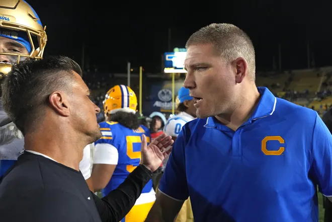 Sep 5, 2026; Berkeley, California, USA; California Golden Bears head coach Tosh Lupoi (right) and UCLA Bruins head coach Bob Chesney (left) talk after the game at California Memorial Stadium. Mandatory Credit: Darren Yamashita-Imagn Images