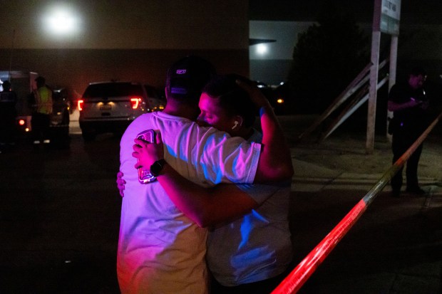 Two people hug each other behind police lines at the scene of a helicopter crash in Chatsworth, a neighborhood in Los Angeles, Tuesday, Sept. 15, 2026. (AP Photo/Ethan Swope)
