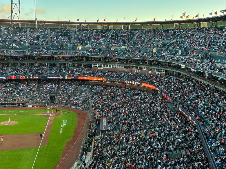 A packed baseball stadium filled with spectators watching a game in progress.