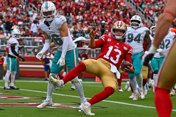 San Francisco 49ers starting quarterback Brock Purdy (13) gets hit by Miami Dolphins' Michael Taaffe (16) after scoring a touchdown against the Miami Dolphins in the second quarter of their NFL game at Levi's Stadium in Santa Clara, Calif., on Sunday, Sept. 20, 2026. (Jose Carlos Fajardo/Bay Area News Group)