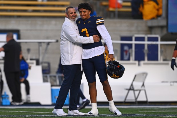California Golden Bears interim head coach Nick Rolovich hugs quarterback Jaron-Keawe Sagapolutele (3) before the start of their game at Memorial Stadium in Berkeley, Calif., on Saturday, Nov. 29, 2025. (Jose Carlos Fajardo/Bay Area News Group)