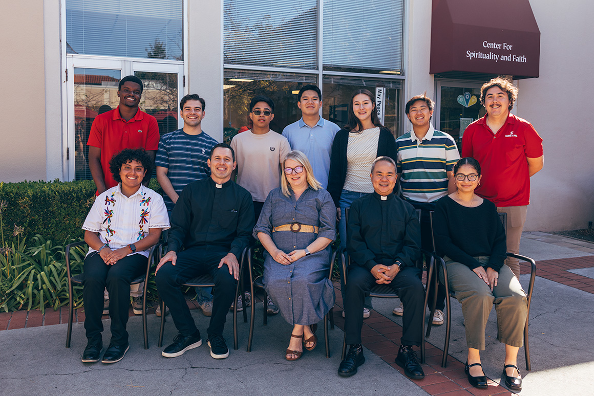 12 leaders and students from Center for Spirituality and Faith posing in front of CSF office