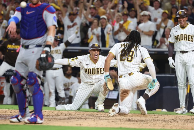 Padres third baseman Manny Machado and right fielder Fernando Tatis Jr. celebrate after Tatis scored from first on a stolen base in the seventh inning against the Cubs in Game 1 of their wild-card series on Sept. 29, 2026, in San Diego. (Brian Cassella/Chicago Tribune)