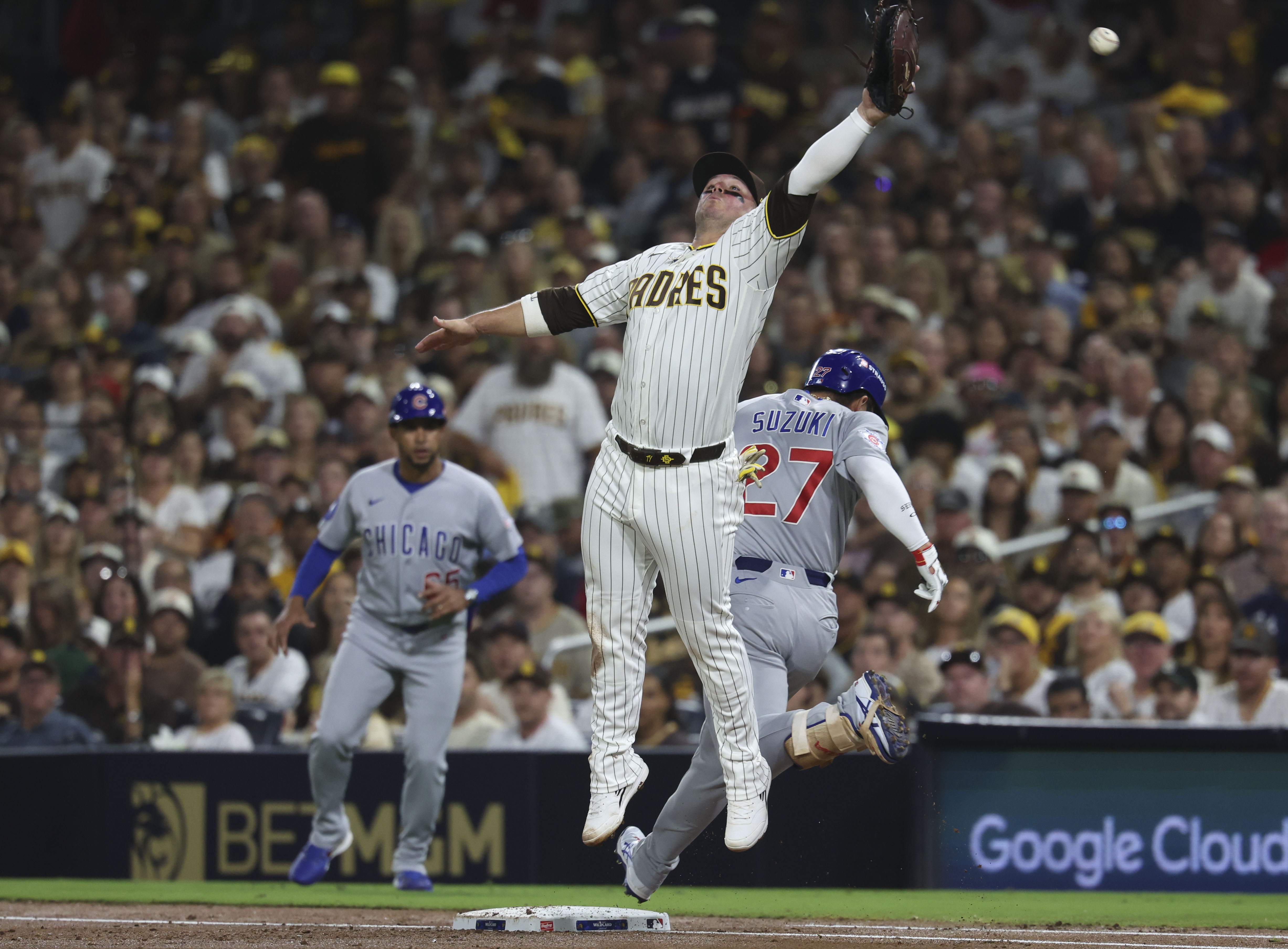 Cubs right fielder Seiya Suzuki reaches first base as Padres first baseman Ty France can't reach the throw in the second inning in Game 1 of their wild-card series on Sept. 29, 2026, in San Diego. (Brian Cassella/Chicago Tribune)