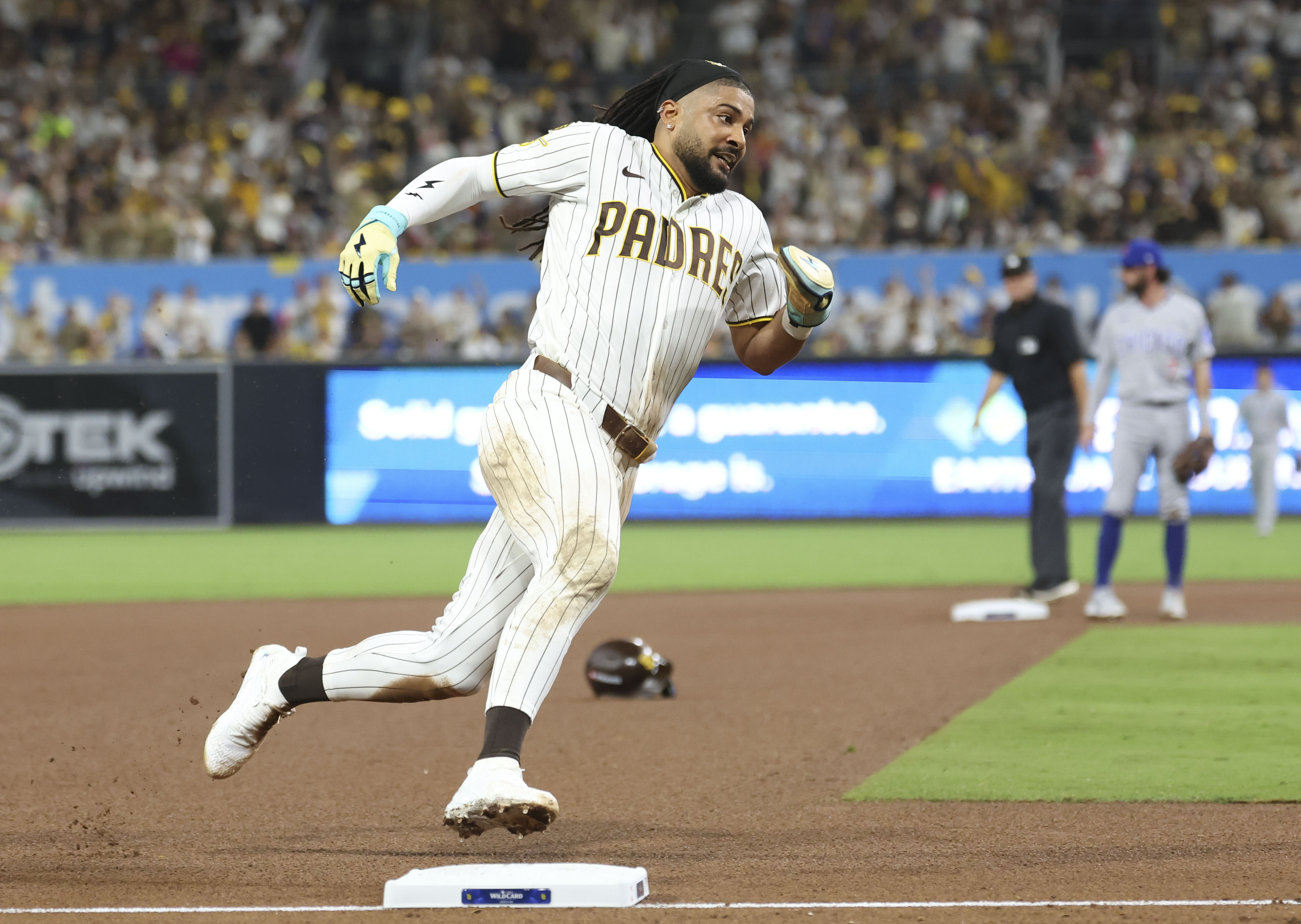 Padres right fielder Fernando Tatis Jr. rounds third base and scores after losing his helmet on a stolen base in the seventh inning against the Cubs in Game 1 of their wild-card series on Sept. 29, 2026, in San Diego. (Brian Cassella/Chicago Tribune)