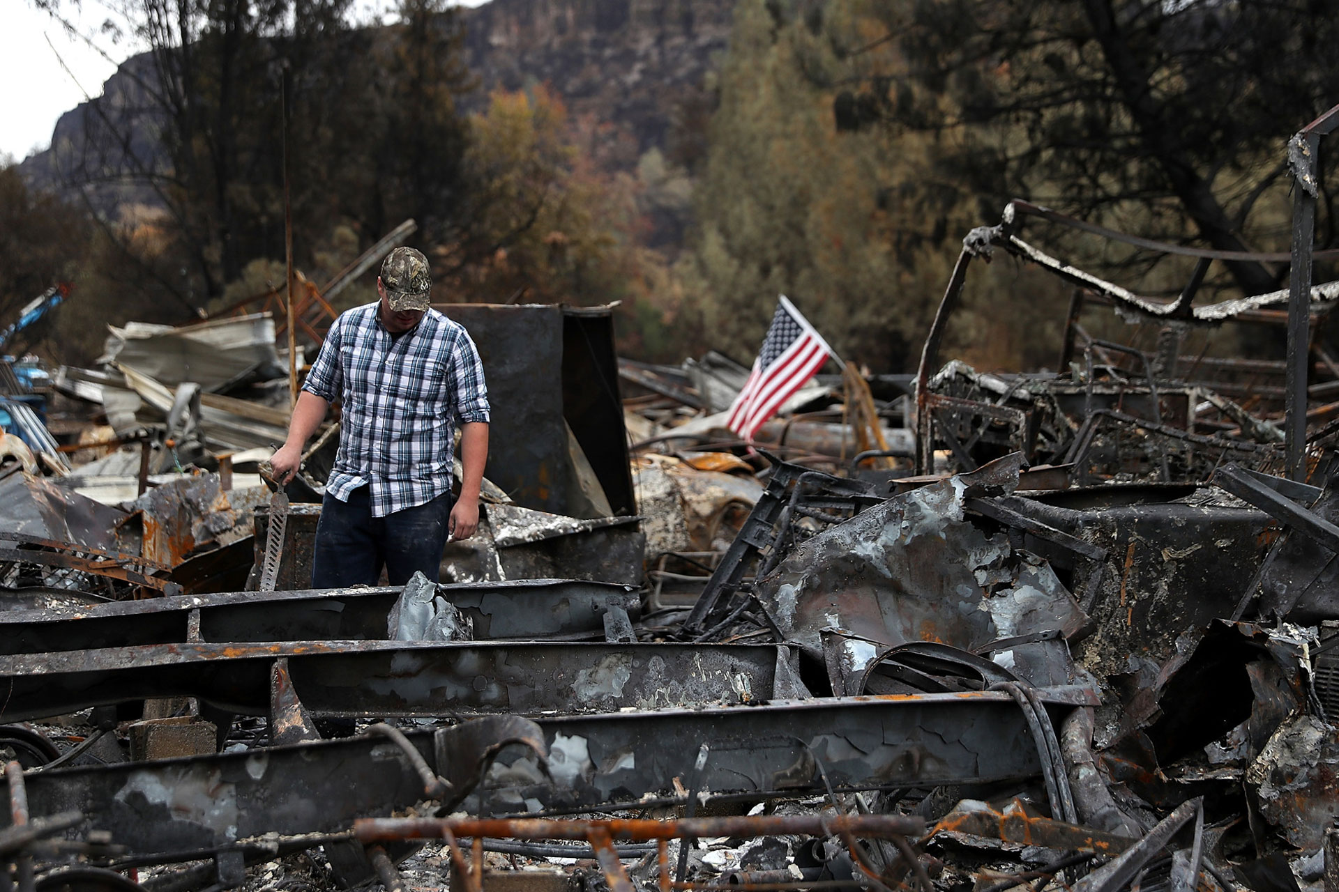 A man looks over his burned home, destroyed by the Camp Fire in Nov. 2018 in Paradise. The deadline for 70,000 survivors of numerous fires to vote on a multi-billion-dollar settlement deal with PG&E was May 15.