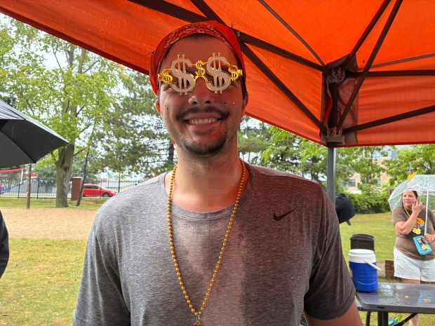 Oxford Bank's Dragon Boat Race team member Erik Gojcaj of Clarkston dons a pair of sunglasses before the team's race on Sunday. (Gina Joseph, for The Oakland Press)