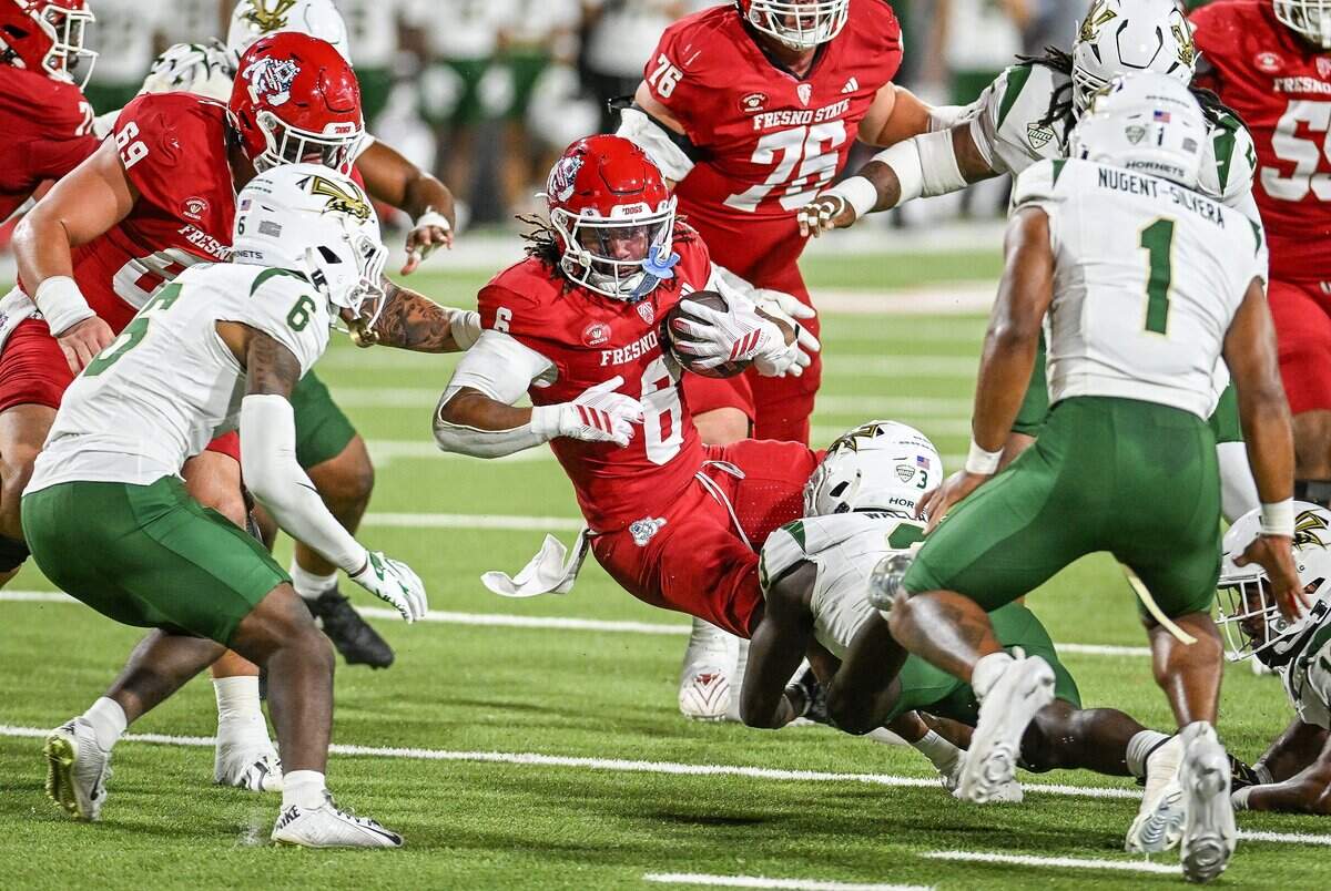 Fresno State's Bryson Donelson, center, gets taken down by Sacramento State's Amari Wallace on a run up the middle during their game at Valley Children's Stadium in Fresno on Saturday, Sept. 12, 2026.