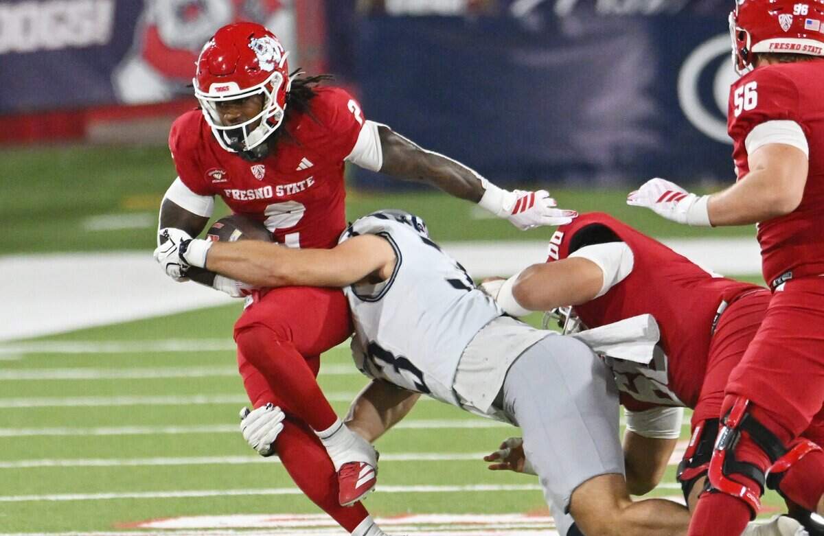 Fresno State's Rayshon Luke, left, carries the ball against Rice Saturday, Sept. 26, 2026 in Fresno. Rice led 17-14 at halftime.