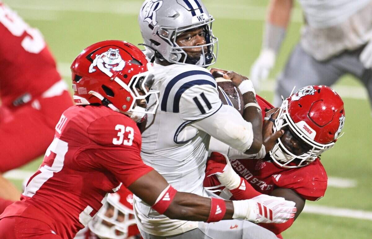 Fresno State's Taylor Powell, left, and K'vion Thunderbird, right, bring down Rice quarterback Jacurri Brown, center, in second quarter action Saturday, Sept. 26, 2026 in Fresno. Rice led 17-14 at halftime.