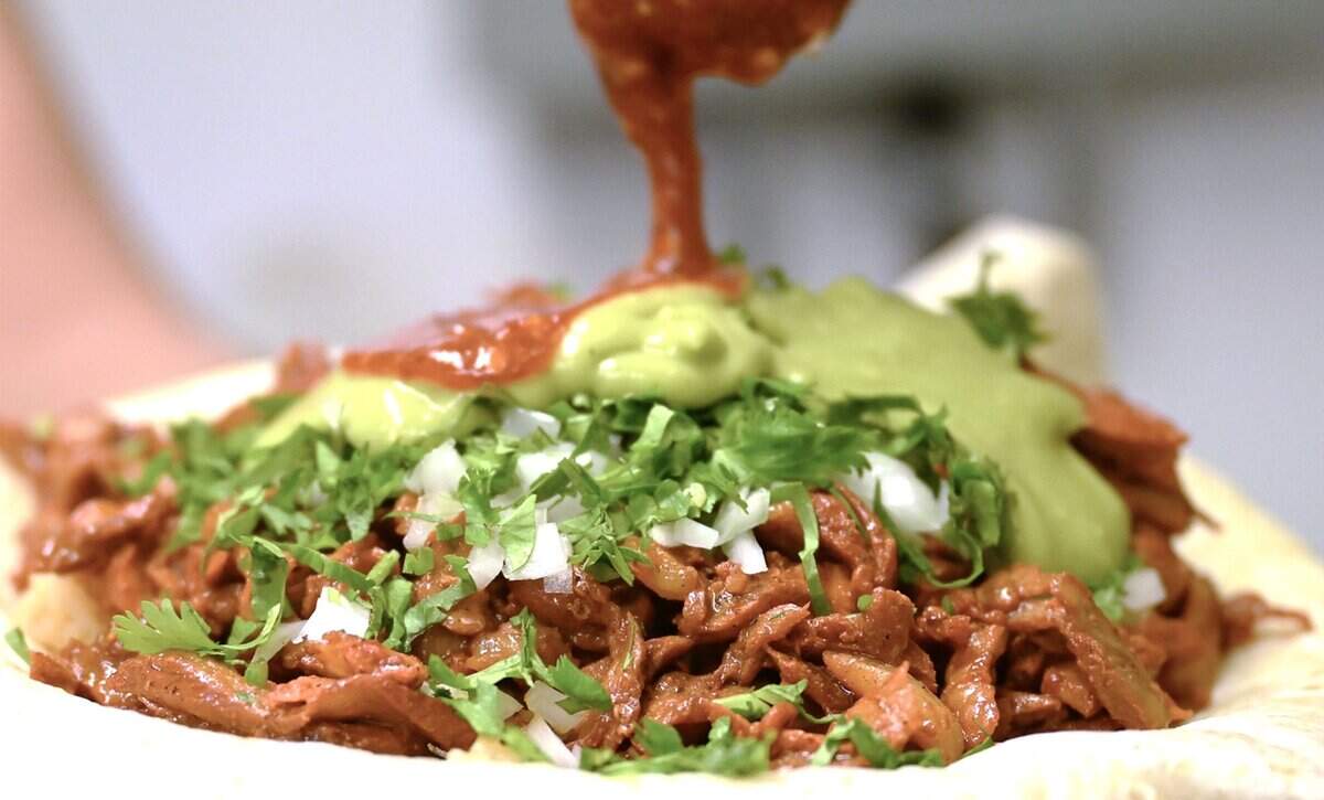 Salsa is added to an al pastor burrito from Tacos El Cabezon, a food truck parked at the corner of Shaw and Marks avenues. Photographed Wednesday, Sept. 24, 2025 in Fresno.