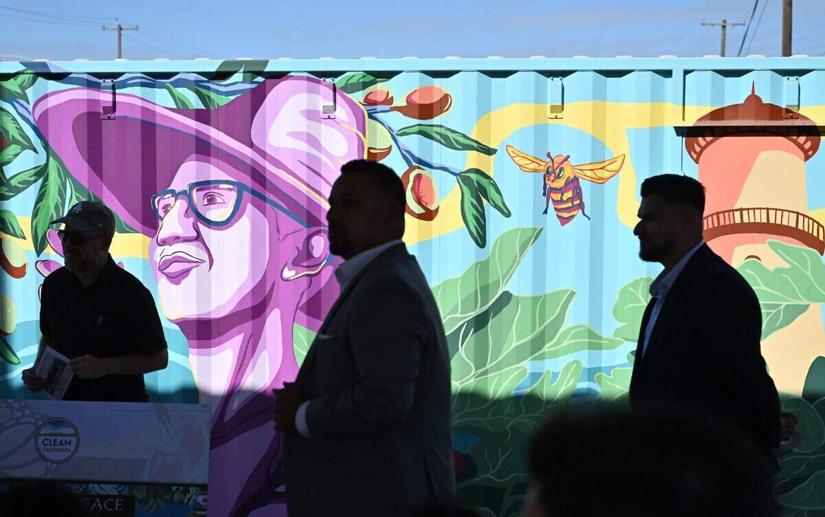 Attendees are silhouetted by a mural after a ribbon-cutting ceremony at the new McKinley Peace Garden Friday morning, Sept. 4, 2026 in Fresno. The garden, located right next to the 41 southbound on-ramp, offers both raised and ground level concrete planters.