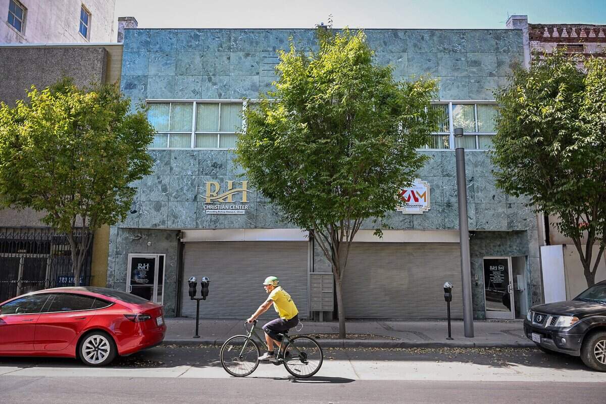 A cyclist rides by the RH Christian Center on Fulton Street in downtown Fresno. Many buildings in the downtown area are available for sale or lease and a property owner says the market there is really good. But a lot of work is needed: more parking, more engagement between the city and businesses that could open locations in those spaces.
