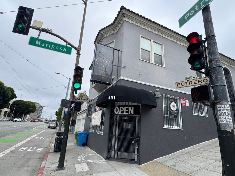 The GDL Reserve Tequila Lounge sits on the corner of Mariposa and Potrero Streets in San Francisco, featuring a grey building, a black awning, and traffic signals at the intersection.