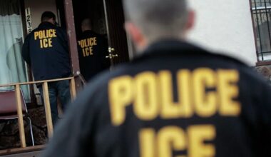 ICE agents wearing jackets marked “Police ICE” enter a home in Oakland.