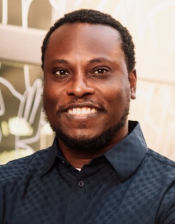 Jason Collins headshot: black man with short dark hair smiling while wearing collared shirt