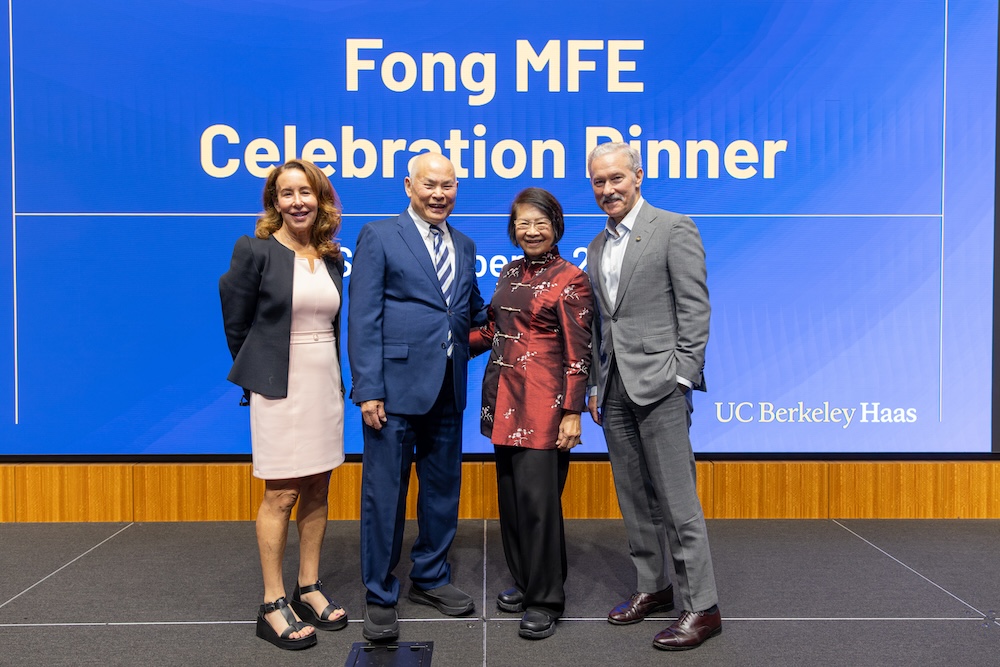 four people standing together at a dinner