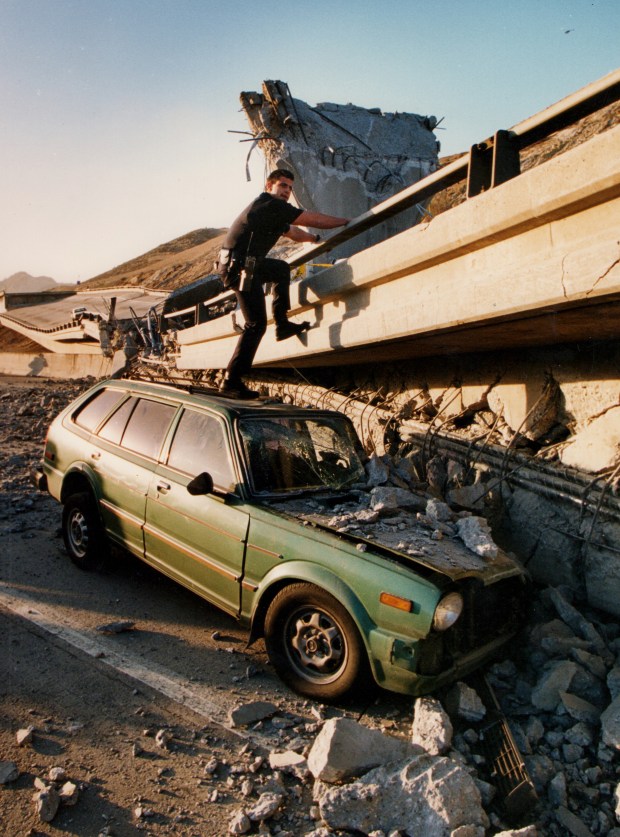 LAPD officer Roger Ruggiero climbs to the top of the Antelope Valley Freeway transition to the Southbound Golden State Freeway where motor officer Clarence Wayne Dean died. Dean, who, while reporting to work in the darkness after the 4:31 AM quake, fell from the partially collapsed bridge when he was unable to stop in time. The Northridge Earthquake registered 6.6 on the richter scale. Sylmar, CA. 1/17/1994, photo by (John McCoy/Los Angeles Daily News)