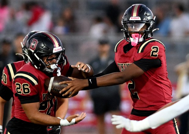 Downey quarterback Chase Watkins (2) hands off the ball to running back Max Acosta (26) in the first half of a prep football game against Millikan at Downey High School in Downey on Friday, September 4, 2026. (Photo by Libby Cline Birmingham, Contributing Photographer)