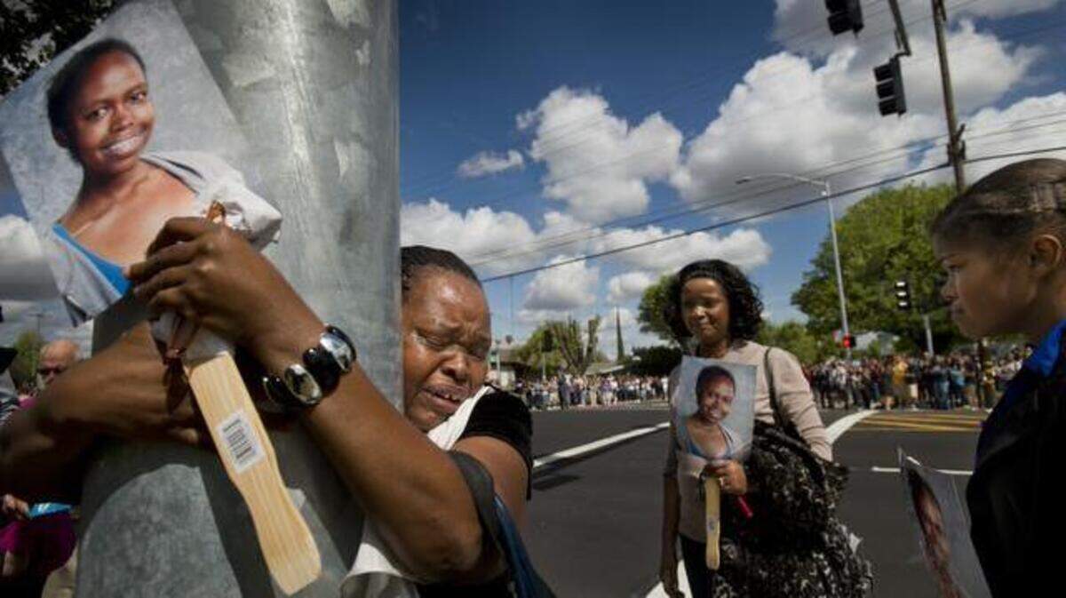 Mary Murigi hugs a new traffic signal at 58th Street and Fruitridge Road - the intersection where her daughter Michelle Murigi, 16, was struck and killed by a car in January 2012. On Tuesday, the Sacramento City Council approved a $2.25 million project addressing road safety issues near seven schools, including at the intersection where Murigi was killed.