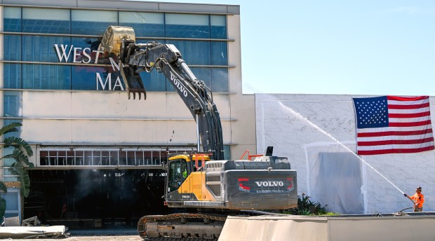 Bill Shopoff operates an excavator as he tears down an entrance to Westminster Mall in Westminster, CA, on Wednesday, April 15, 2026. Shopoff, President and CEO of Shopoff Realty Investments, said he recognized the responsibility developing a legacy site, "You're not just replacing buildings. You're stewarding a piece of community history while shaping what comes next.". The 83-acre site is slated to become Bolsa Pacific, a mixed-use development by Shopoff Realty that promises open space, retail and approximately 2,250 housing units including a new Target. (Photo by Jeff Gritchen, Orange County Register/SCNG)