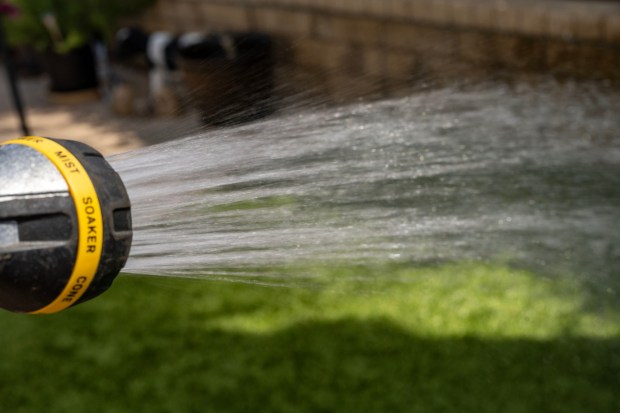 A hose waters grass. (Getty Images)