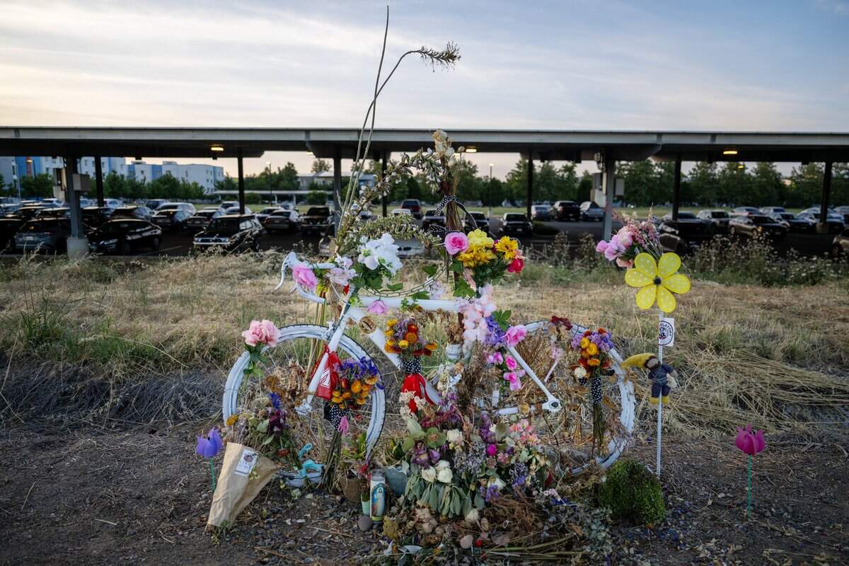 A ghost bike is covered in flowers on Wednesday, May 20, 2026, to remember Lincoln Sabini, a UC Davis student who was killed while cycling, near the crash site on Hutchison Drive. UC Davis police completed its investigation into the fatal crash and allowed the public to access to a partially-redacted copy of the police report on Thursday.