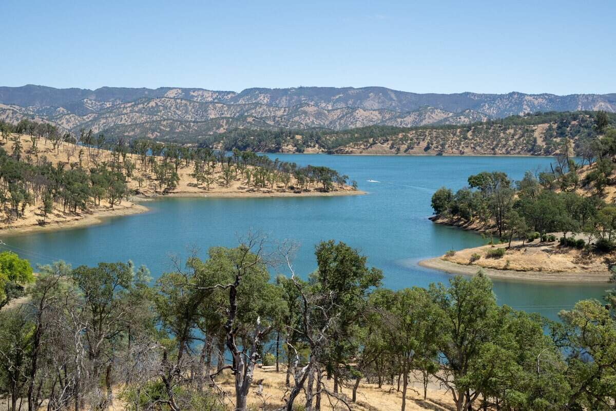 Lake Berryessa, created following construction of Monticello Dam in the 1950s, in July. In 1956, after relocating Monticello's residents and removing or demolishing the town's buildings, the federal government created the reservoir, flooding the valley and submerging the town of Monticello.