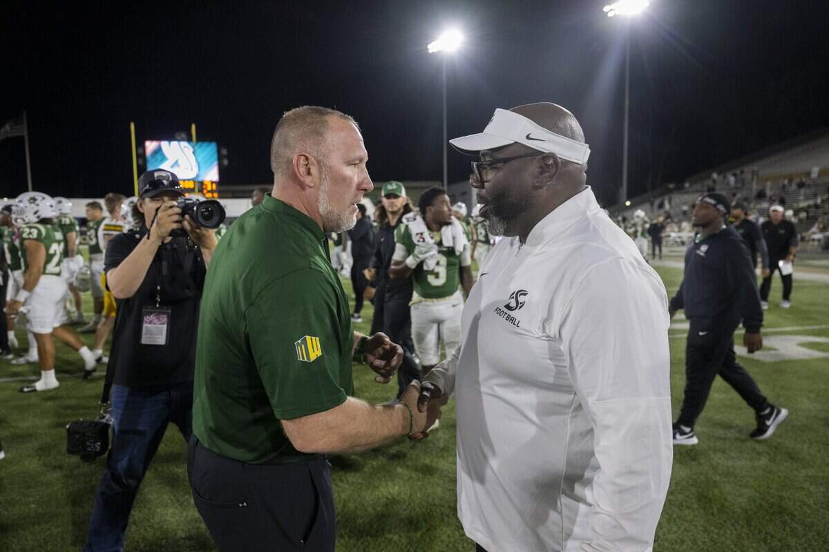North Dakota State Bison head coach Tim Polasek shakes hands with Sacramento State Hornets head coach Alonzo Carter following the game Saturday in Sacramento.