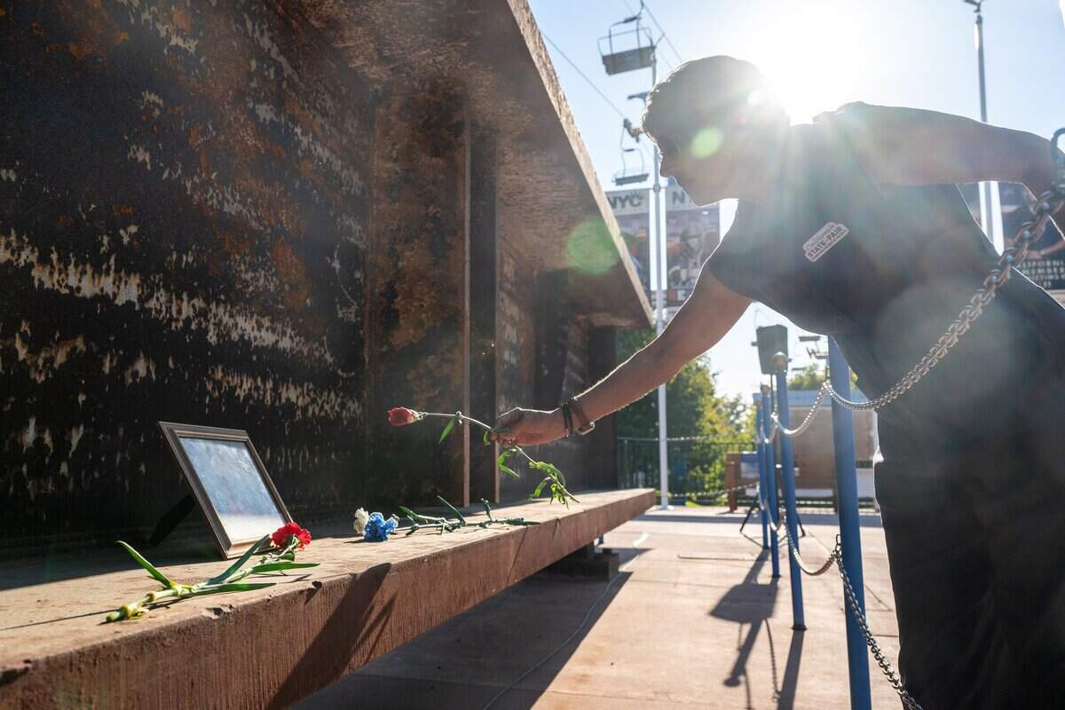 A person lays a flower on the World Trade Center beam during the 9/11 25th anniversary memorial event at Cal Expo in Sacramento on Friday, Sept. 11, 2026.