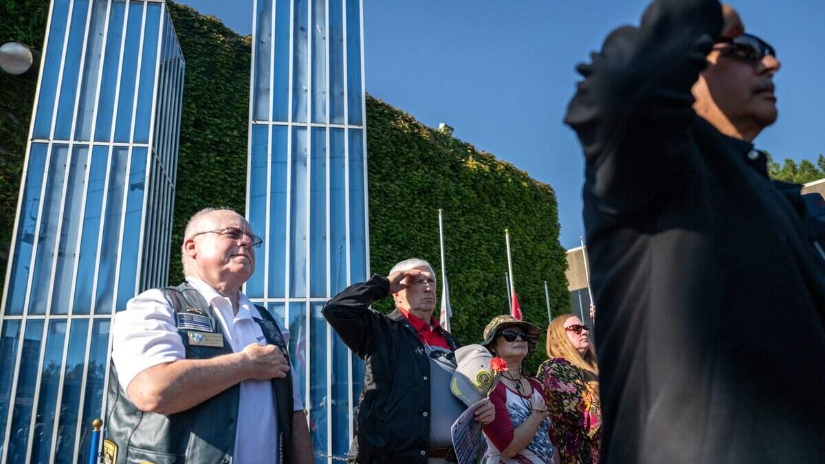 Event participants salute during the singing of the national anthem during the 9/11 25th anniversary memorial event at Cal Expo in Sacramento on Friday, Sept. 11, 2026.